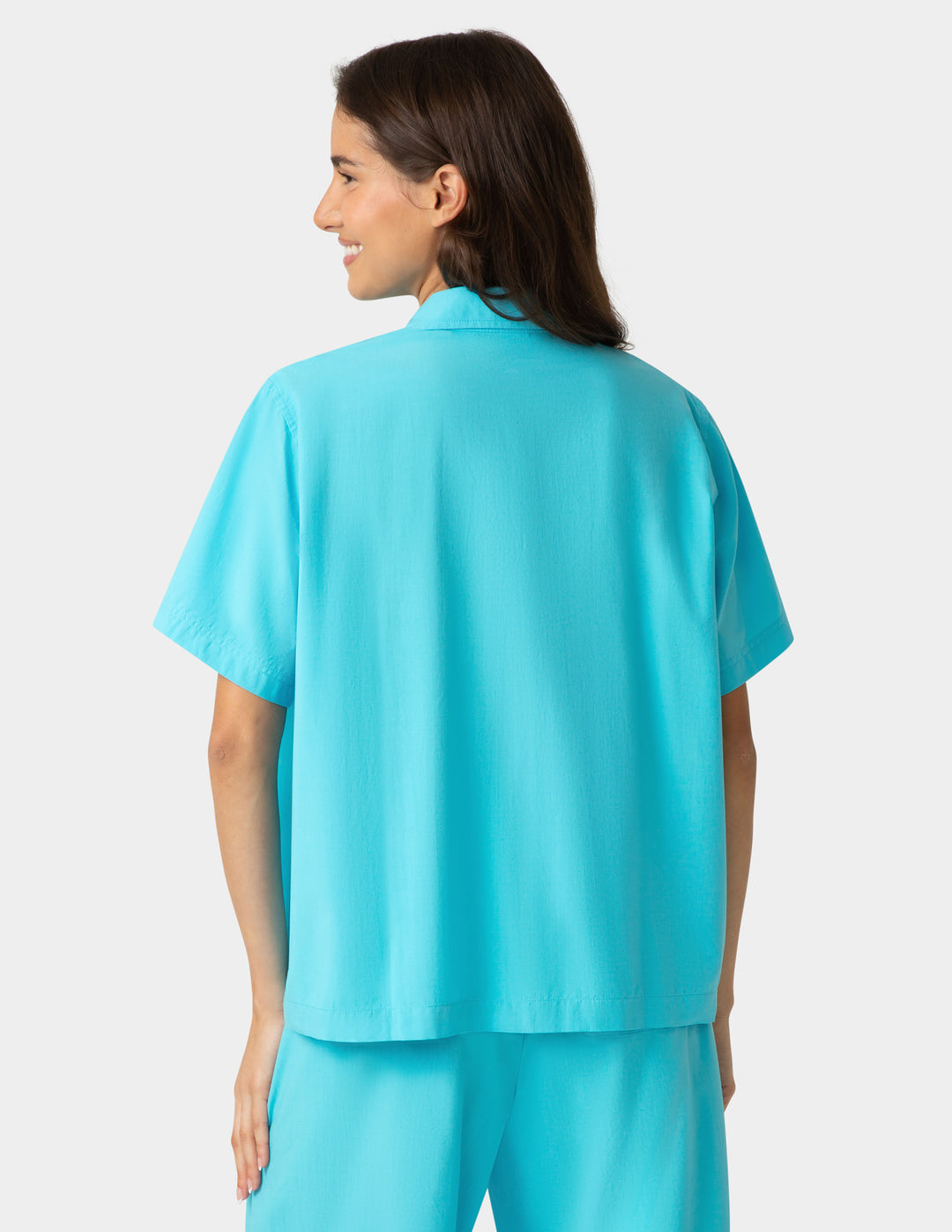 Woman wearing a turquoise outfit on a white background