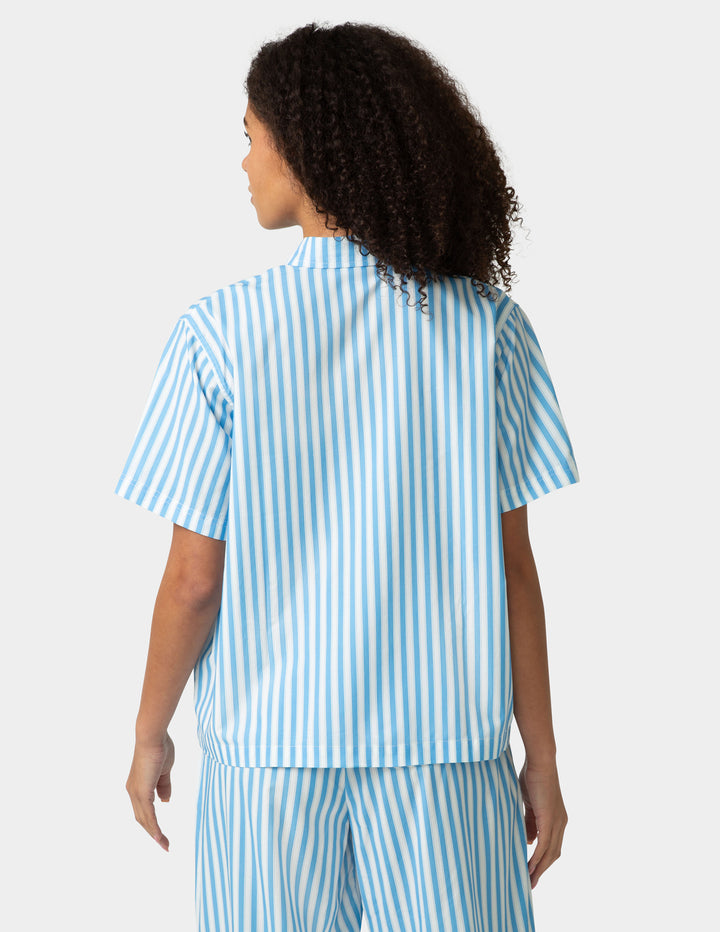 Person wearing a blue and white striped shirt and pants on a white background