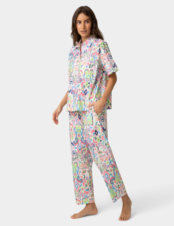 Woman wearing a colorful pajama set on a white background