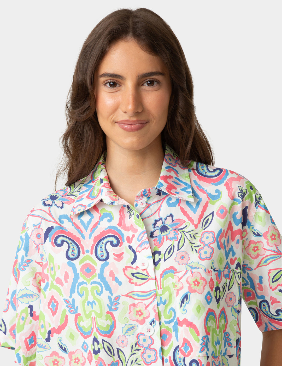 Woman wearing a colorful patterned shirt on a white background