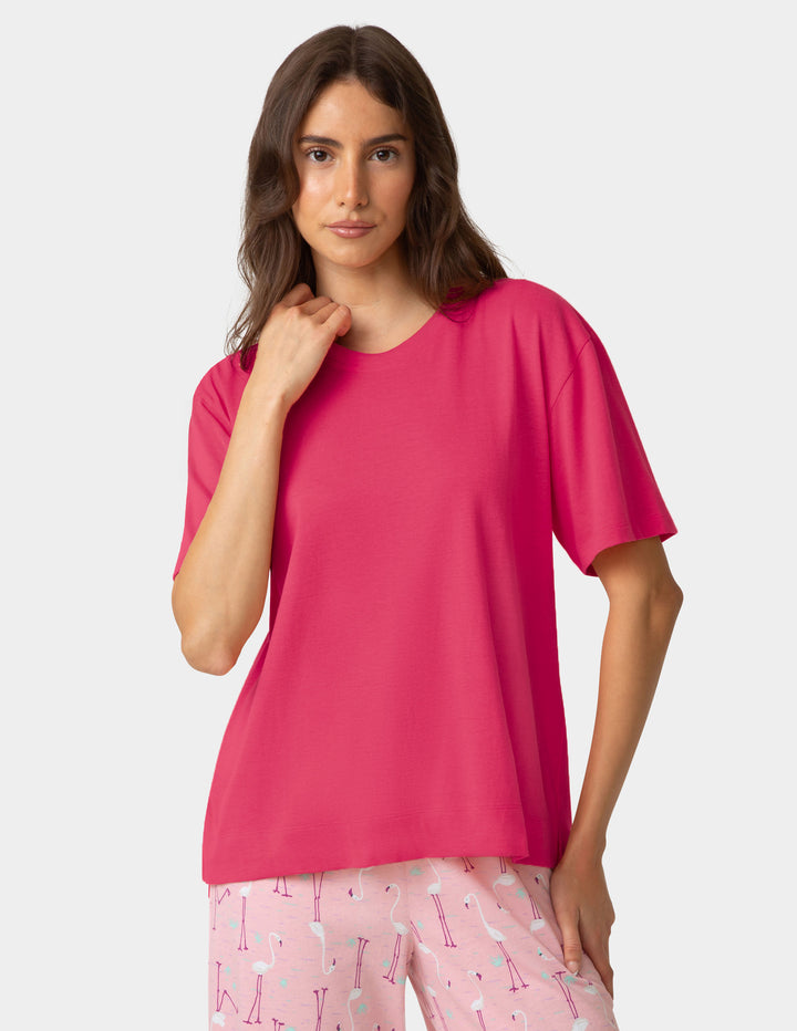Dark pink pajama shirt worn by woman on a white background