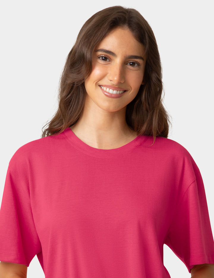 Woman wearing a dark pink pajama t-shirt against a plain background