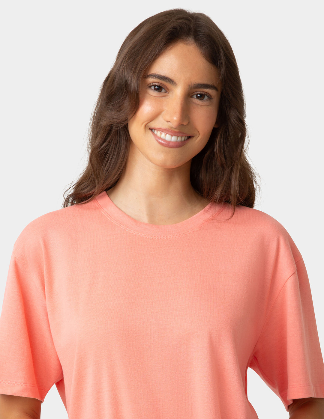 Woman wearing a coral-colored shirt against a plain background