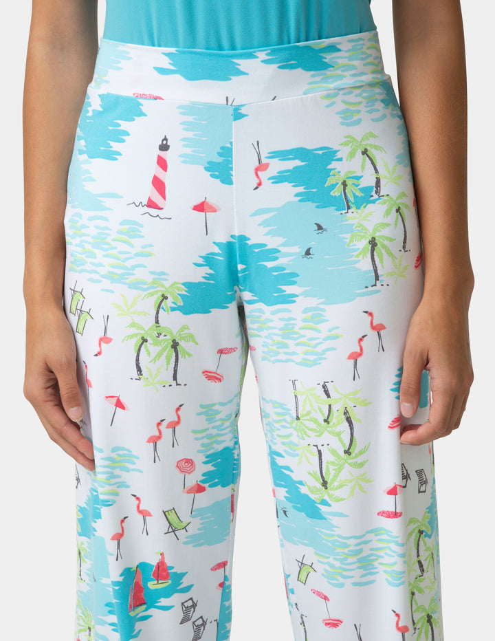 Colorful patterned pants with flamingo, palm tree, and lighthouse design on a white background.