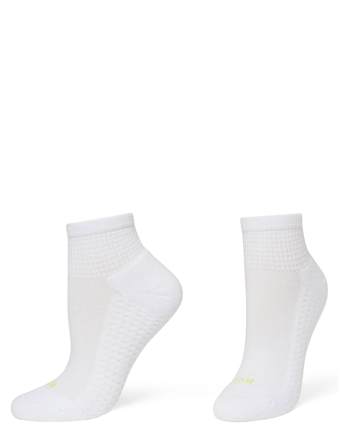 A pair of white low-cut athletic socks with textured knit patterns and small neon yellow branding near the toes, displayed on foot forms against a solid white background.