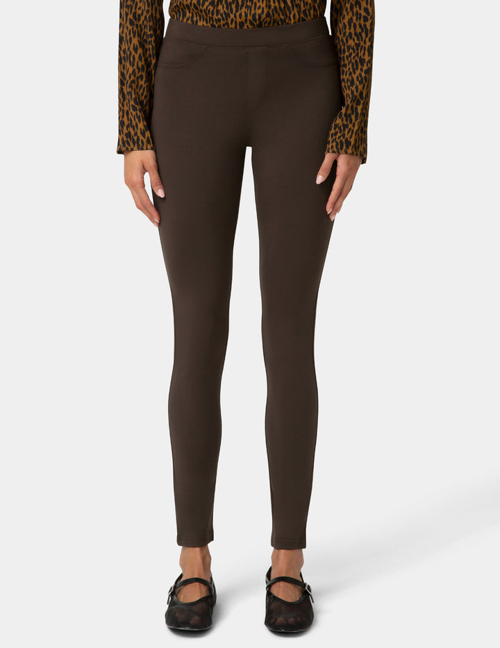 Brown leggings worn with a leopard print top on a white background