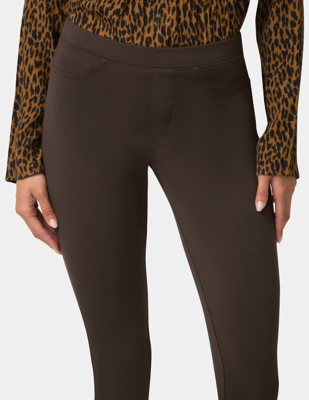 Brown pants worn with a leopard print top on a white background