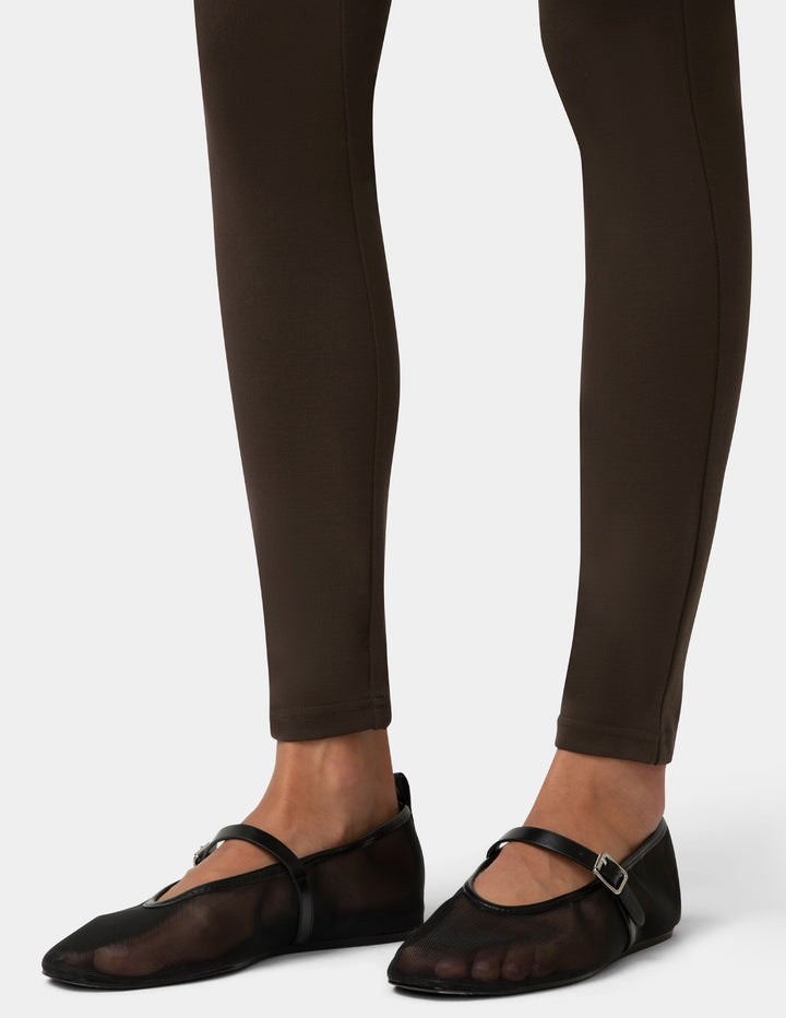 Brown leggings worn by a person on a white background