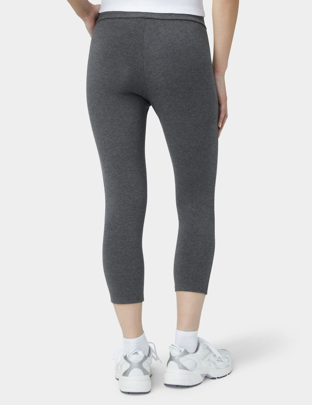 Person wearing gray leggings on a white background