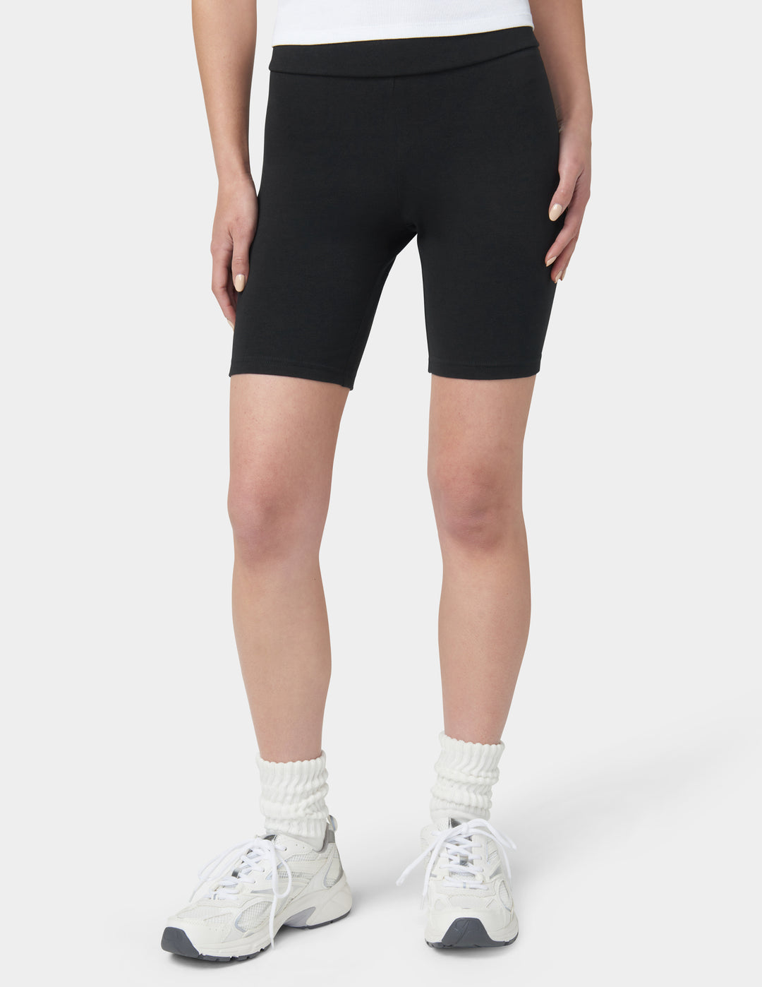 Person wearing black bike shorts on a white background