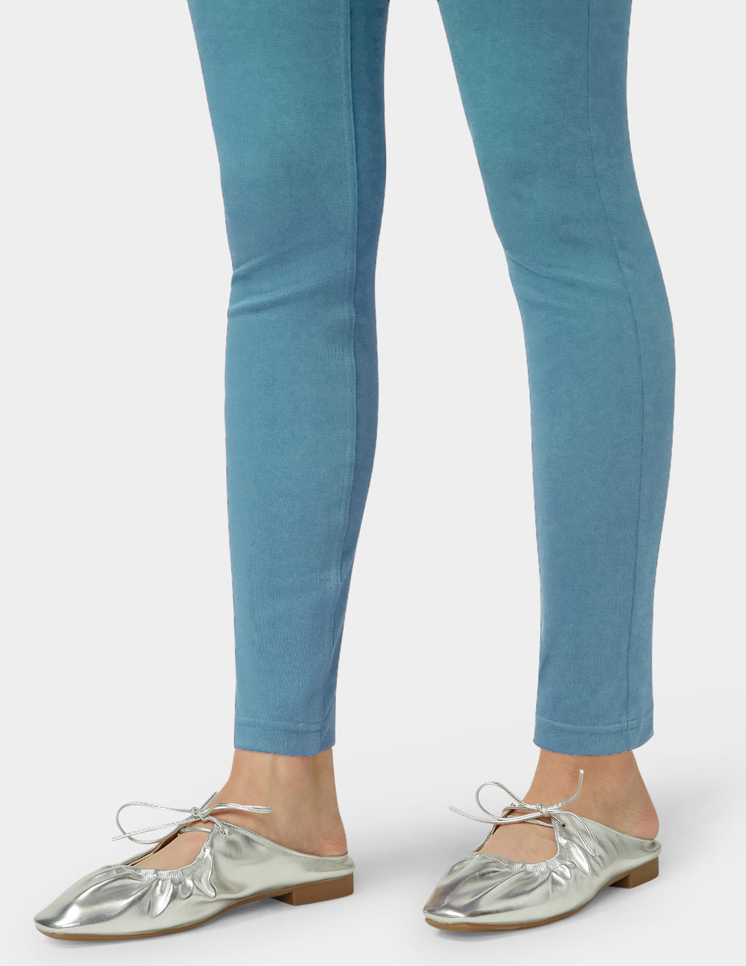 Teal leggings worn by a person on a white background