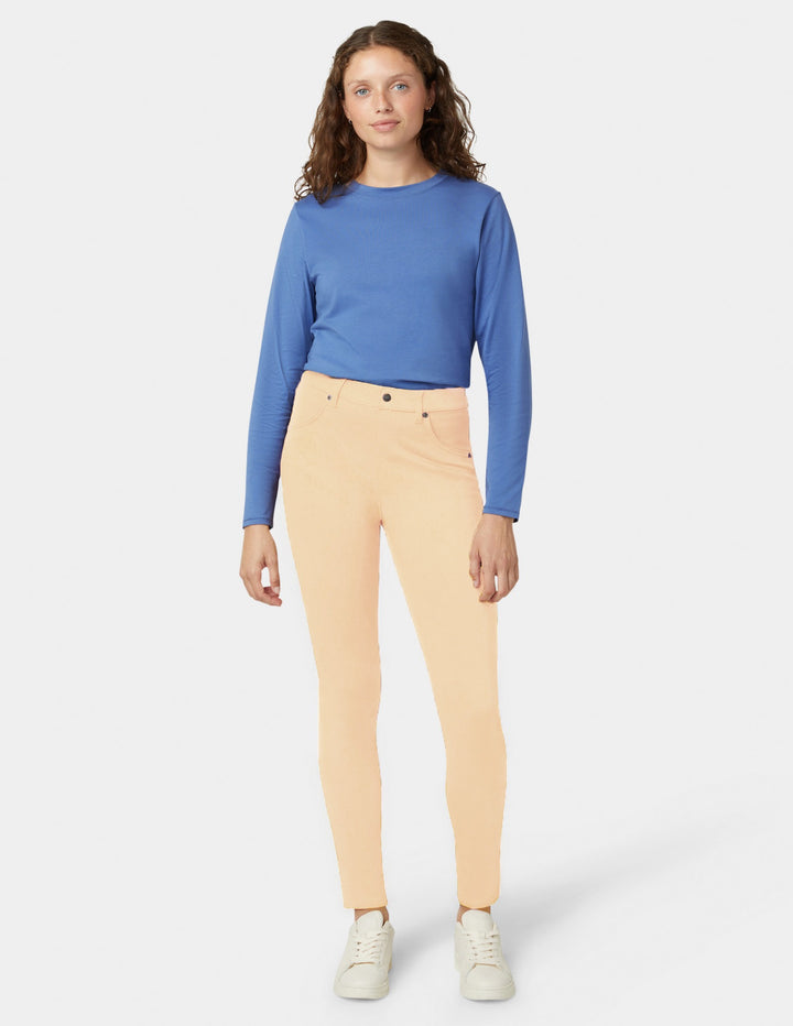 Yellow pants and blue top worn by a woman on a white background