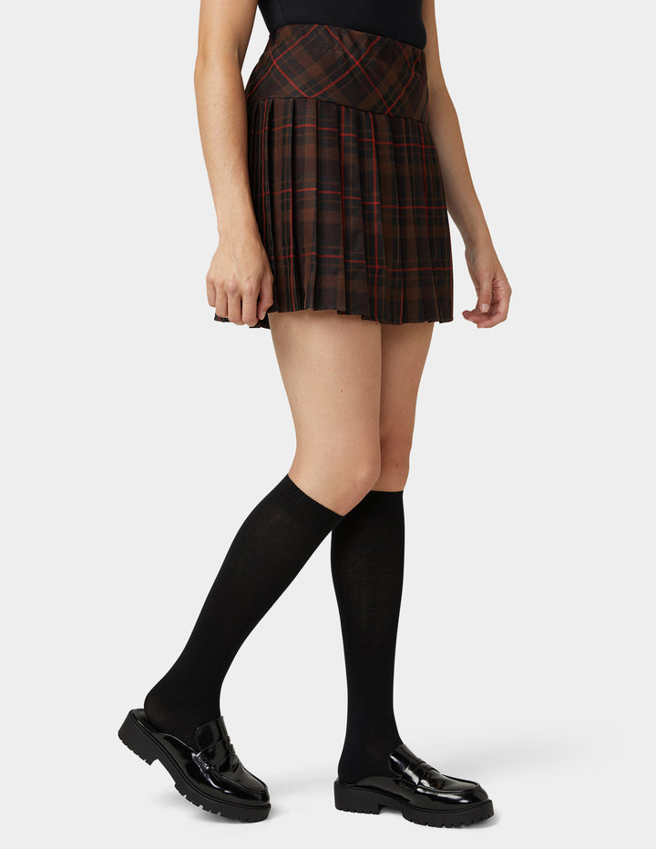 A pair of black knee-high socks worn on a model's legs, shown against a clean light gray studio background.