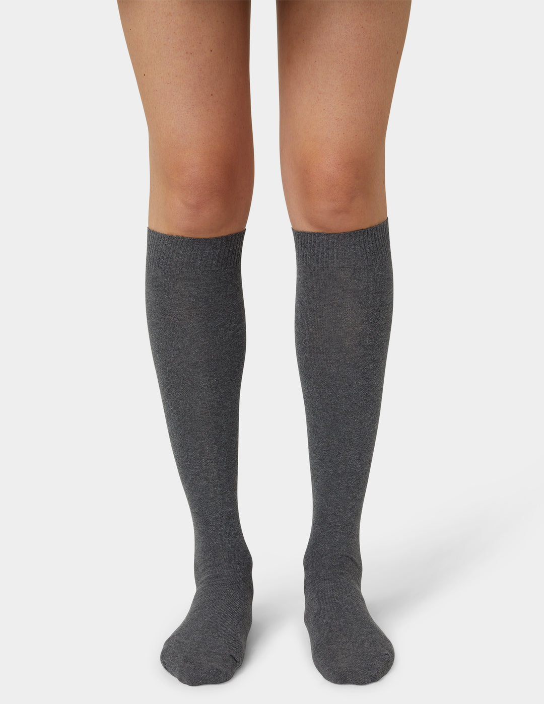 A pair of dark gray heathered knee-high socks worn on a model's legs, shown against a light gray studio background.