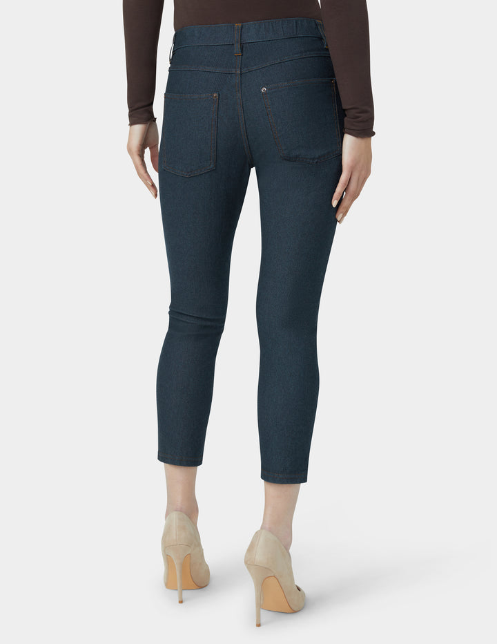 Dark blue jeans worn by a person on a white background