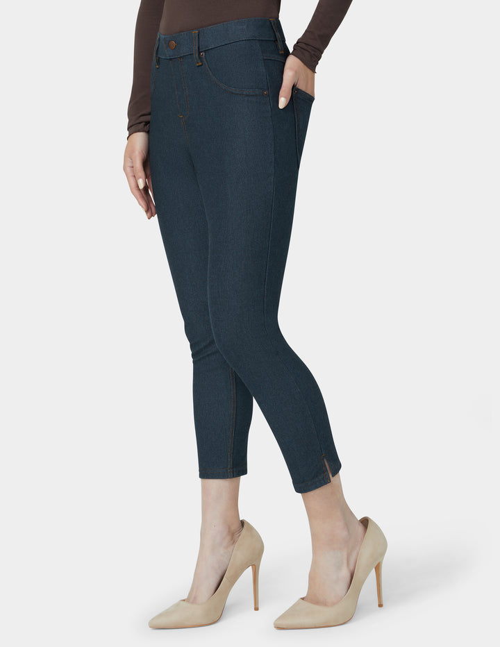 Person wearing dark blue jeans and beige high heels on a white background