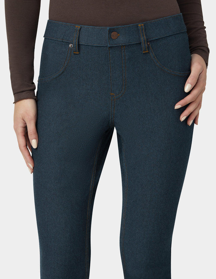 Dark blue jeans worn by a person on a white background