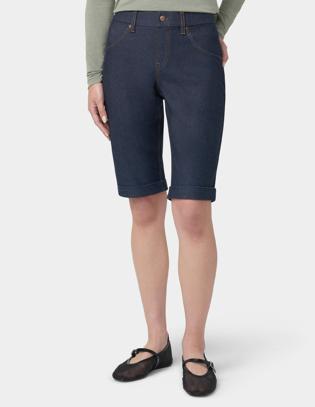 Person wearing dark blue denim shorts on a white background