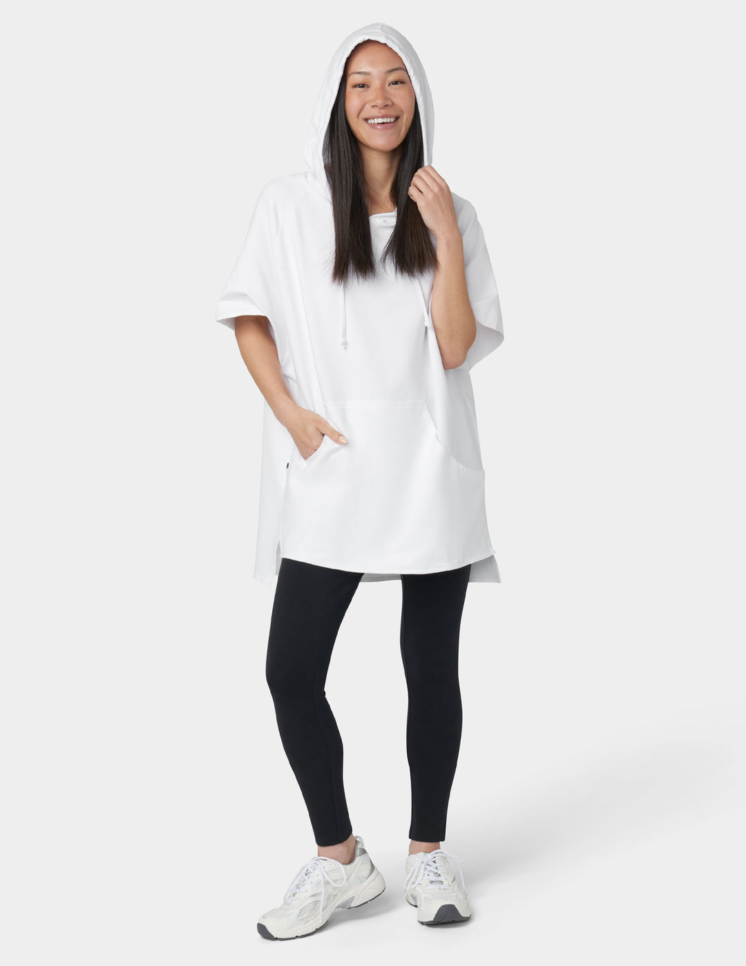 Woman wearing a white hoodie and black leggings on a white background
