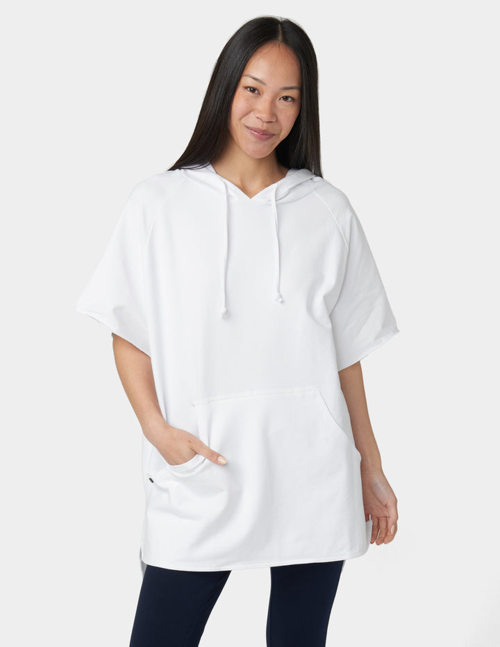 Woman wearing a white hoodie on a plain background