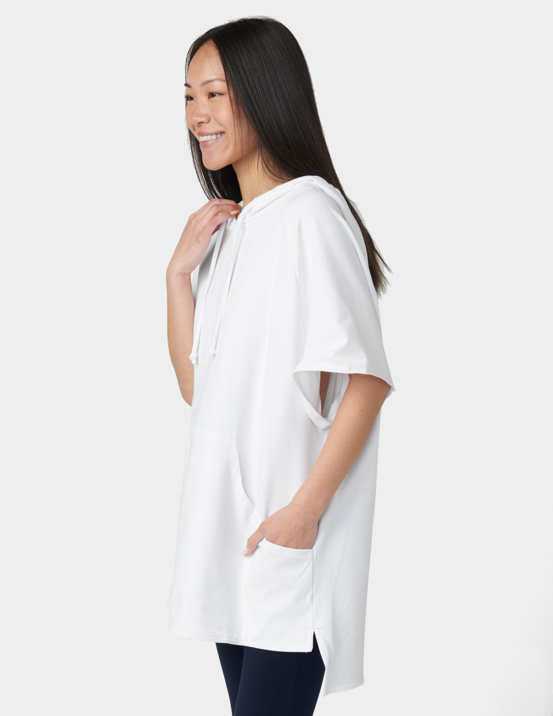 Woman wearing a white oversized t-shirt on a plain background