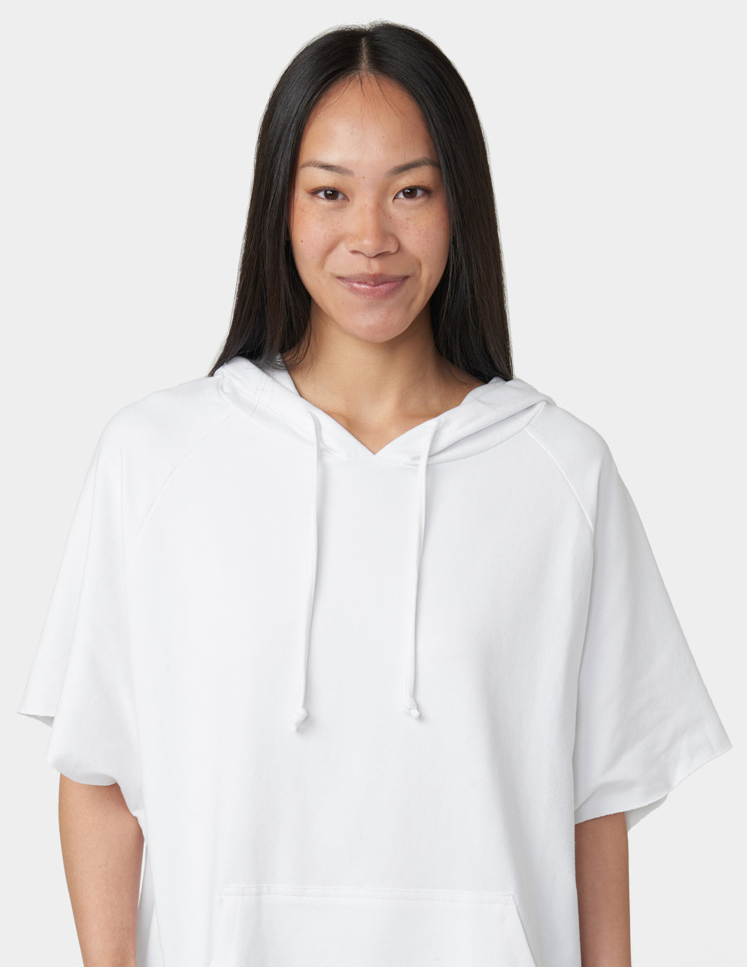 Woman wearing a white hoodie against a plain background