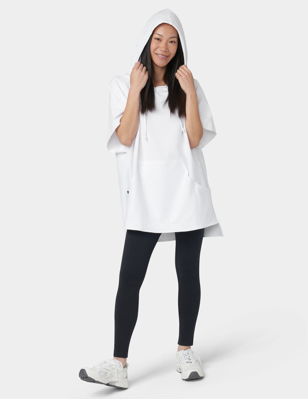 Person wearing a white hooded jacket, black leggings, and white sneakers on a white background