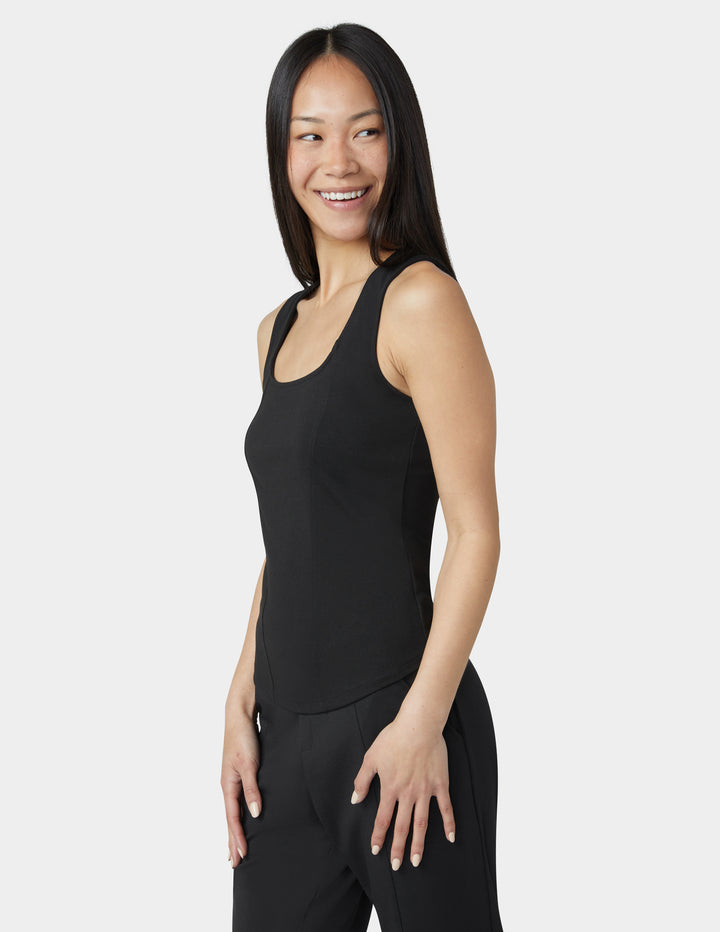 Woman wearing a black sleeveless top and pants on a white background