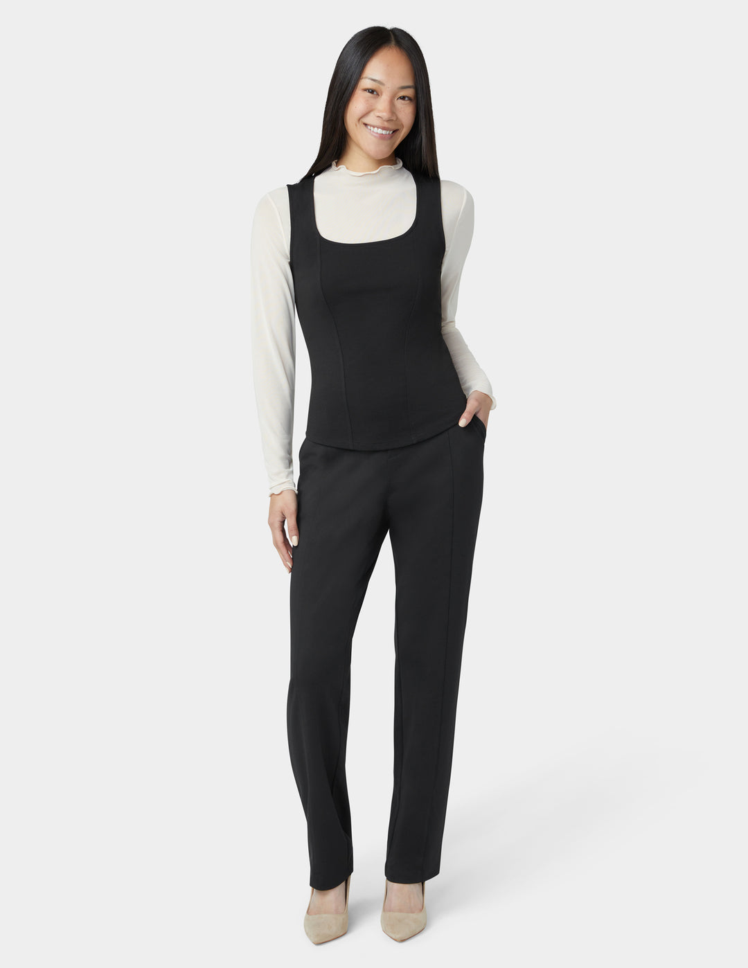 Woman wearing a black sleeveless top and black pants on a white background
