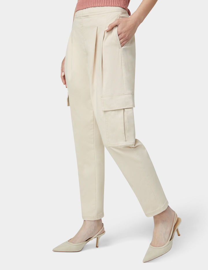 Person wearing beige cargo pants on a white background