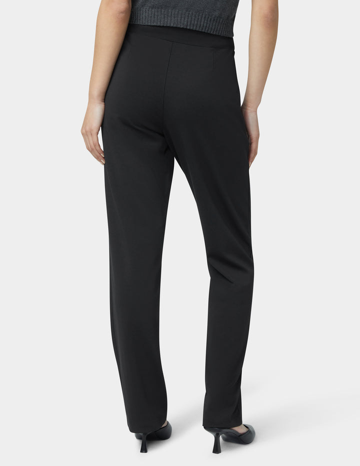 Person wearing black pants on a white background