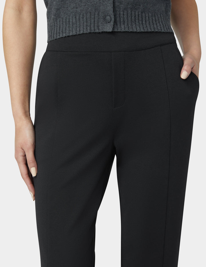 Black pants worn by a person on a white background