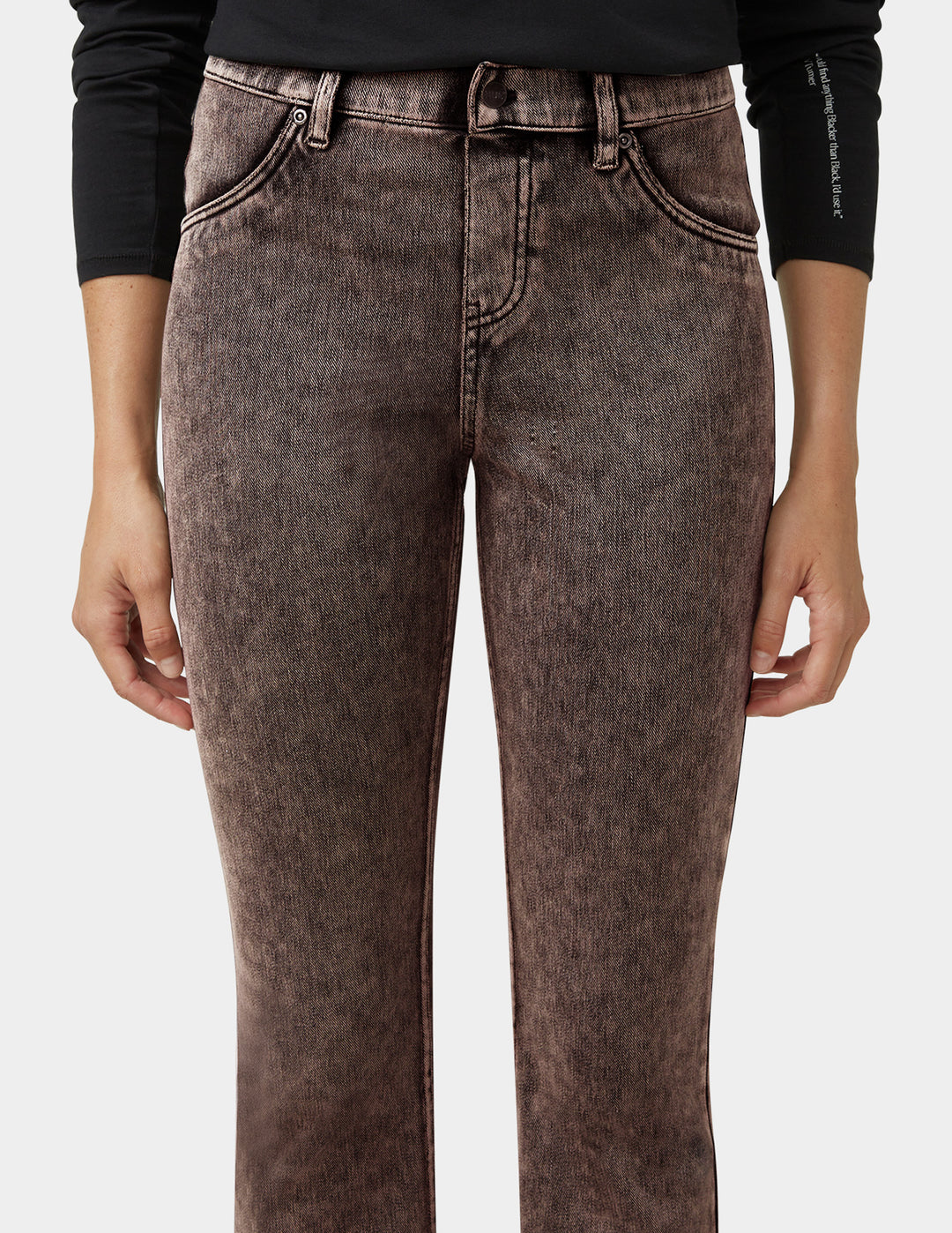 Brown jeans worn by a person on a white background