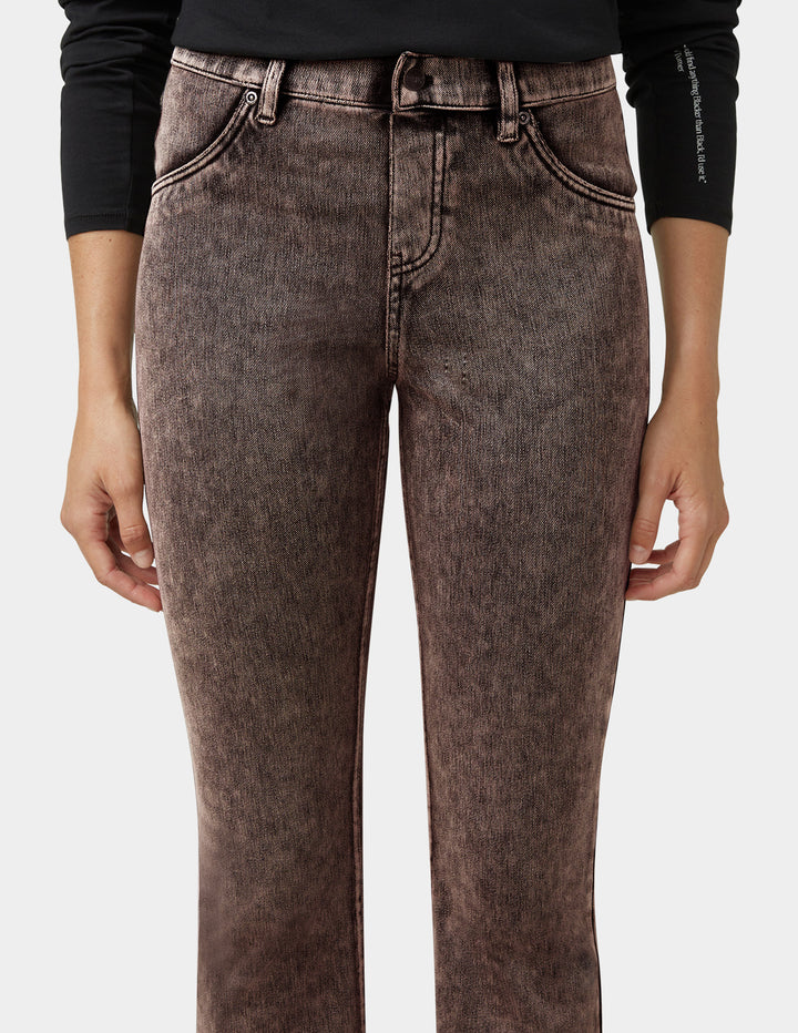 Brown jeans worn by a person on a white background