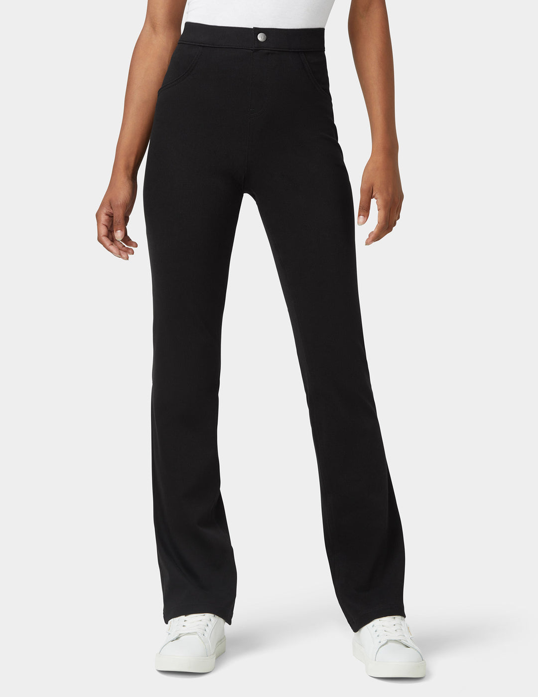 A model wearing bootcut black denim bottoms shown from the waist down