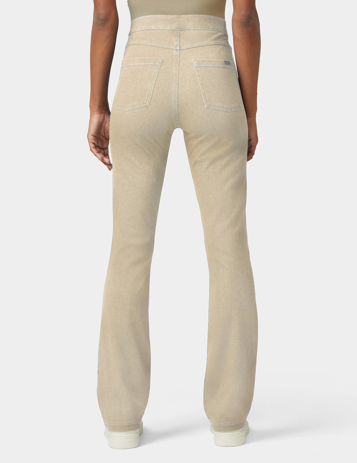 Rear view of a model wearing light beige straight-leg jeans with a high waist and back pockets, paired with a beige top and white sneakers, against a light gray studio background.