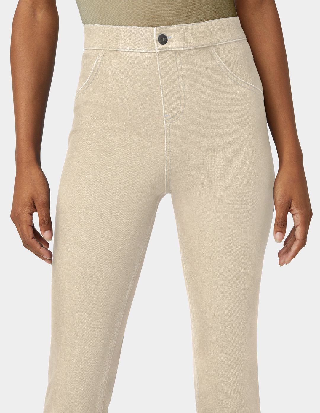 Beige high-waisted slim-fit jeans shown on a model from the waist down, featuring a button closure and front faux pockets.