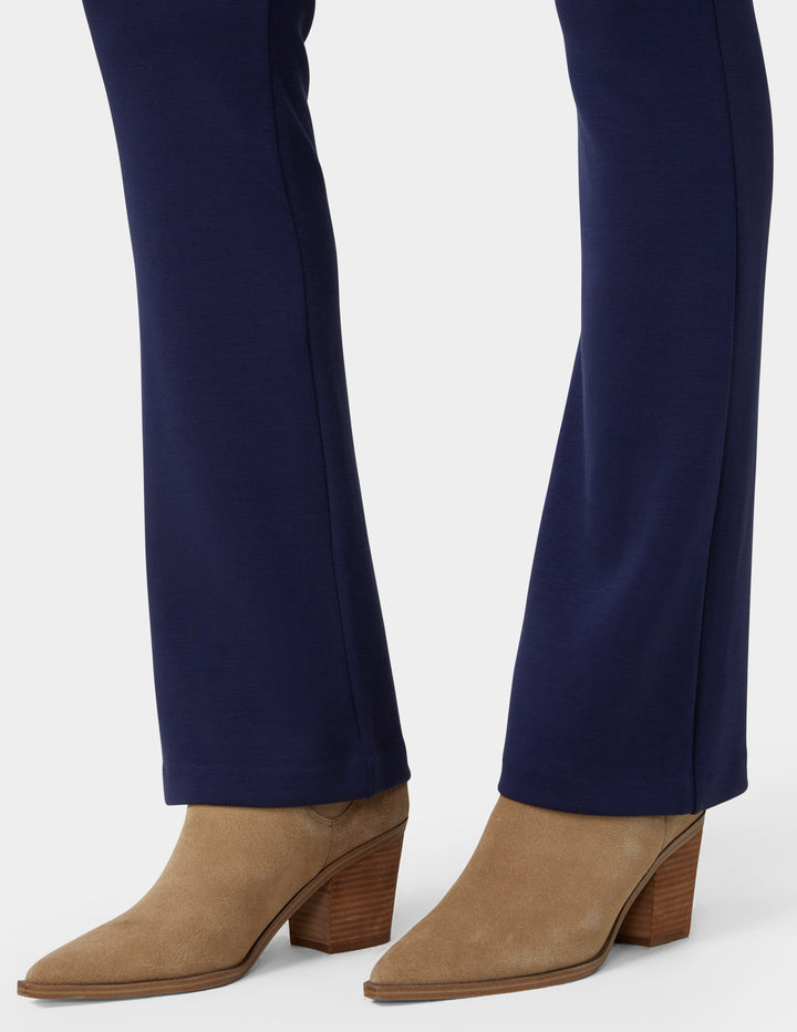 Navy blue pants with tan suede ankle boots on a white background