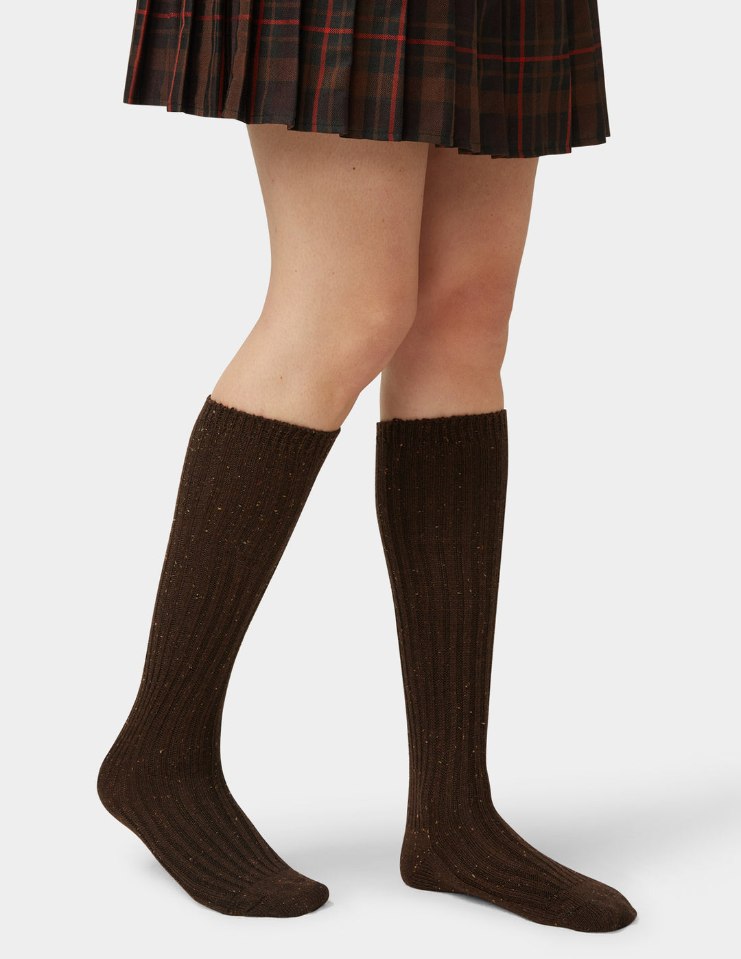 Brown knee-high socks worn with a plaid skirt on a white background