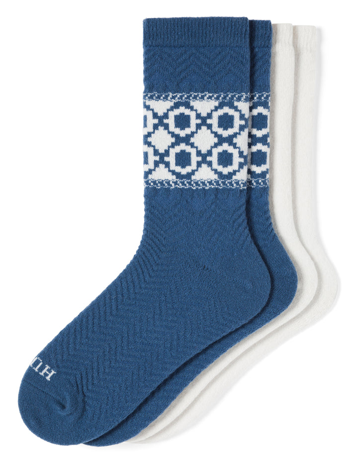 Two pairs of socks, one blue with a pattern and one white, on a white background.