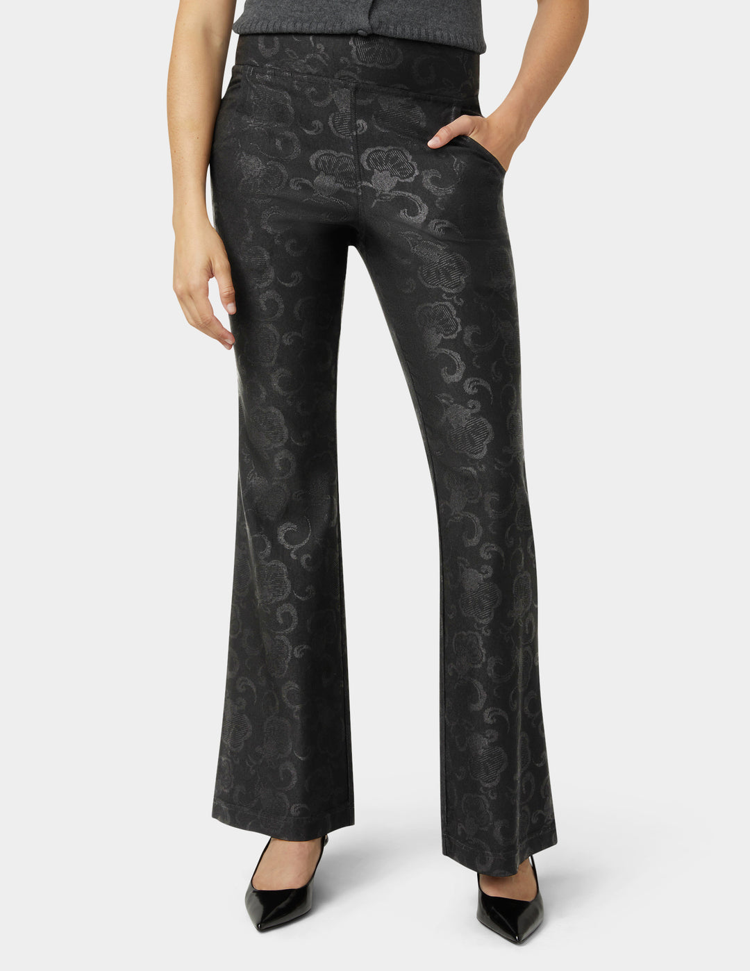 Black patterned pants worn by a person on a white background