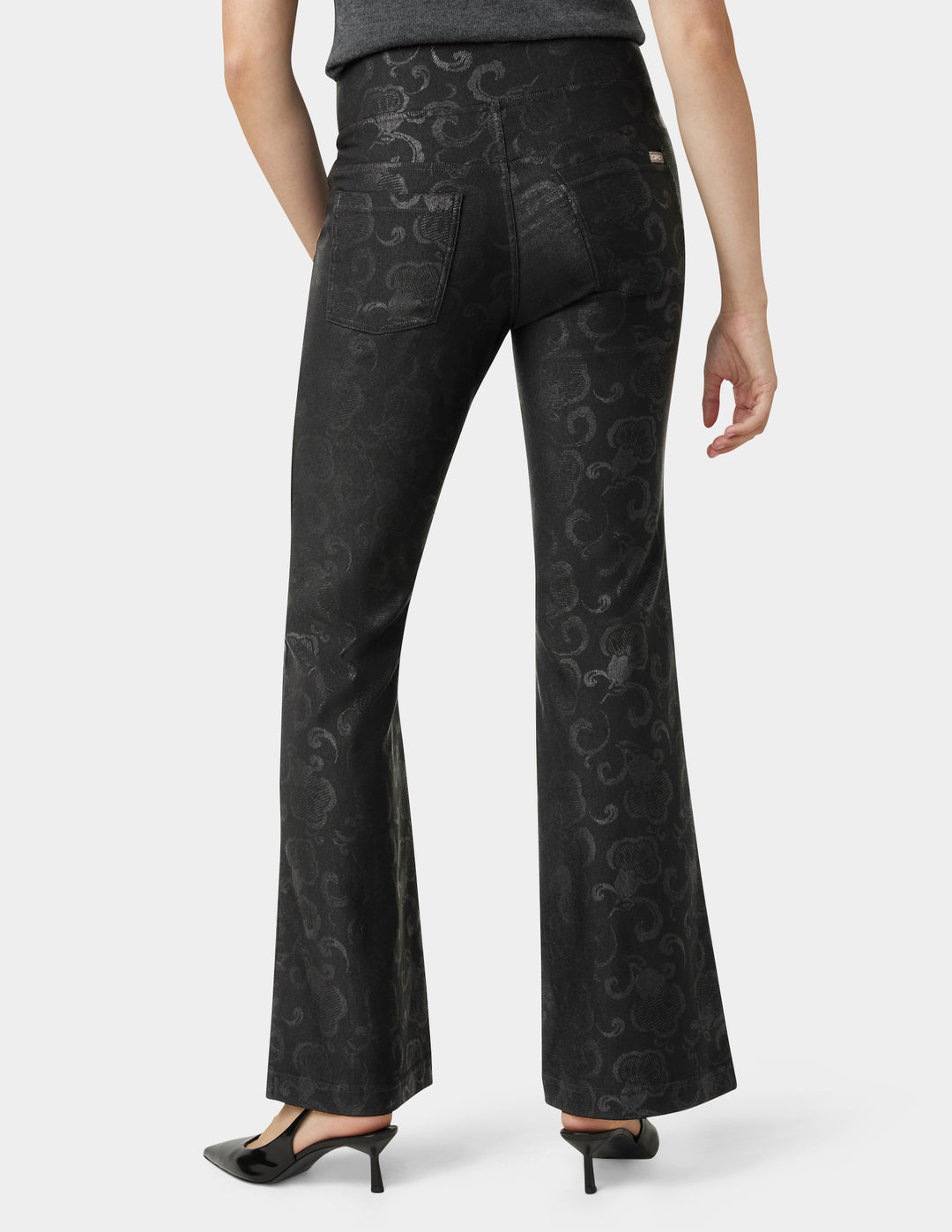 Black patterned pants worn by a person on a white background