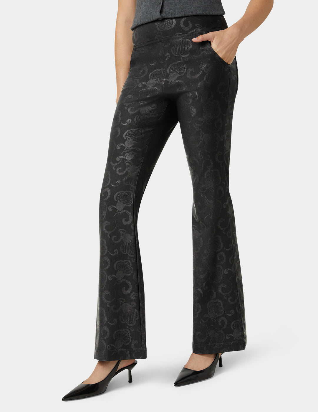 Black patterned pants worn by a person on a white background