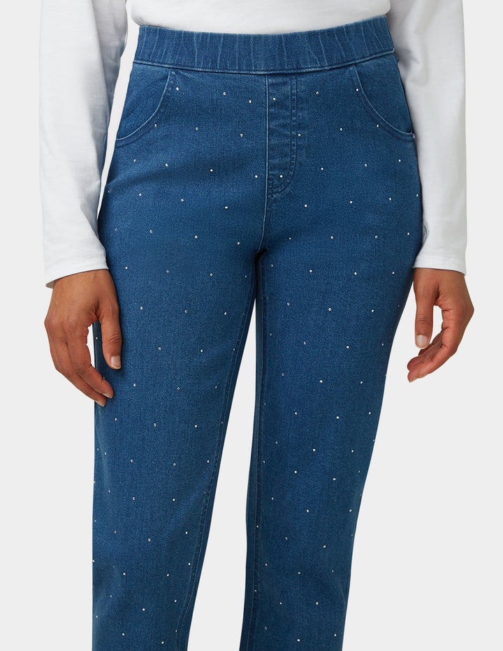 Blue pants with white speckles worn by a person on a white background