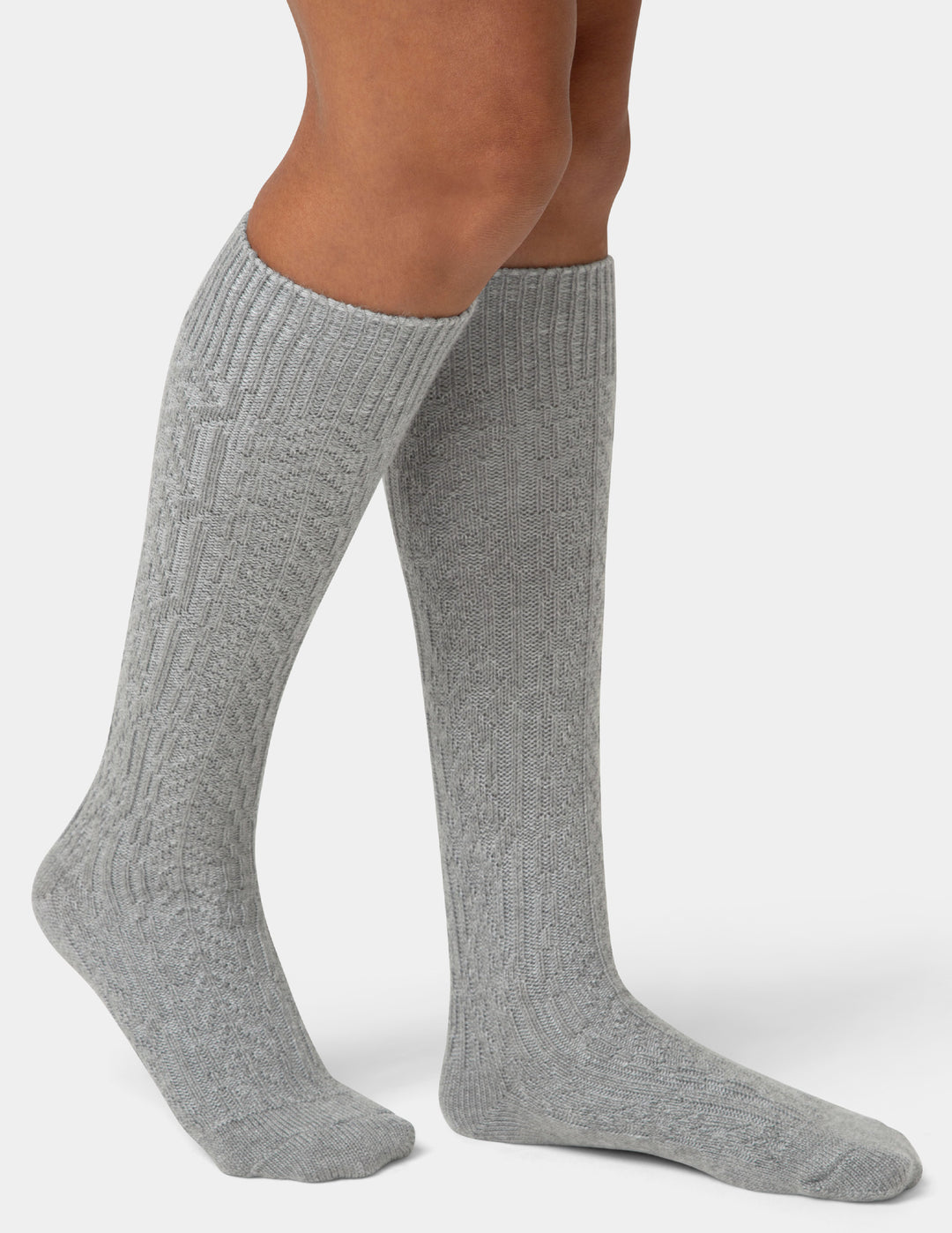 Gray knee-high socks worn by a person on a white background