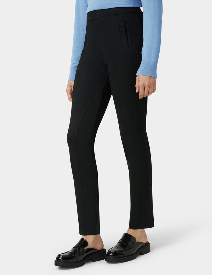 Person wearing black pants and black shoes on a white background