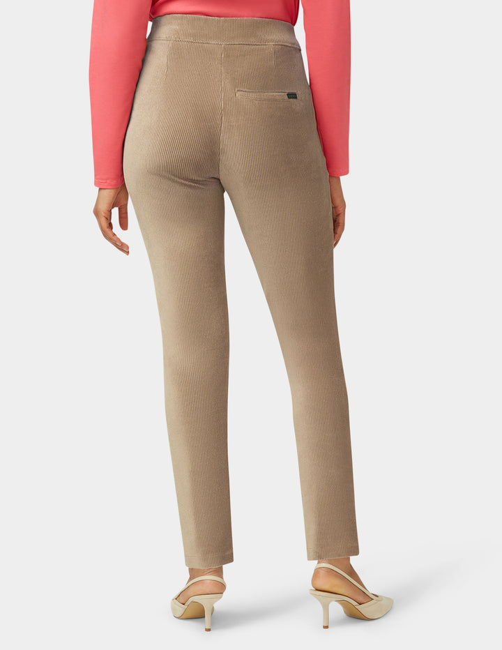 Beige pants worn by a person on a white background