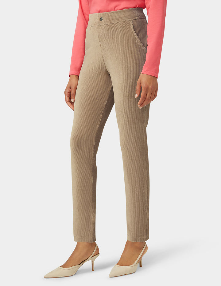 Beige pants worn by a person on a white background