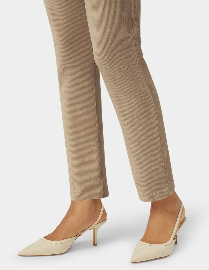 Beige corduroy pants with beige high-heeled shoes on a white background