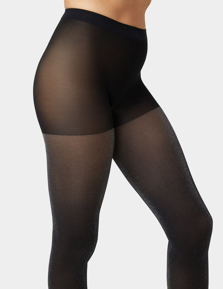 Black sheer tights worn by a person on a light gray background